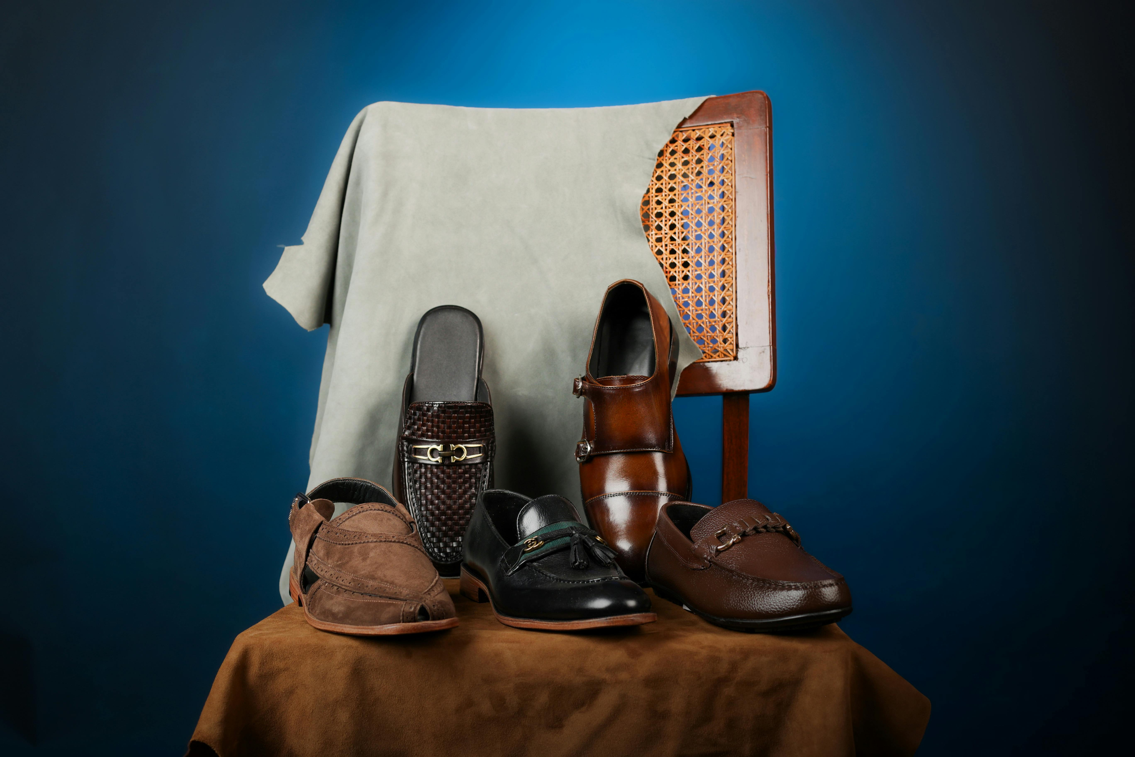 Set of men's dress shoes on a brown tablecloth with a blue background